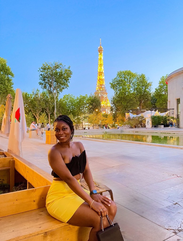 Picture of Ibi in Paris with the Eiffel Tower in the background sparkling at night